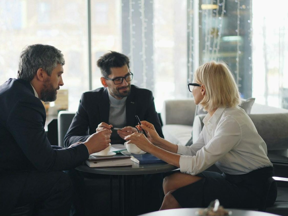 Tres profesionales reunidos alrededor de una mesa